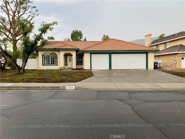 mediterranean / spanish home featuring a front lawn and a garage