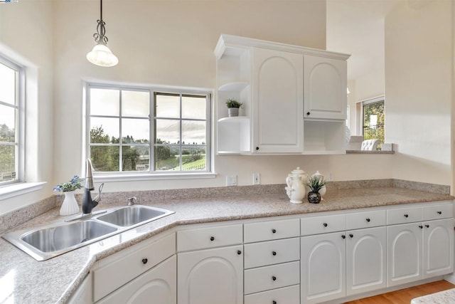 kitchen with white cabinetry, sink, decorative light fixtures, and plenty of natural light