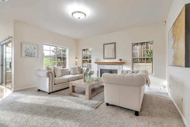 living room featuring light carpet and a tile fireplace