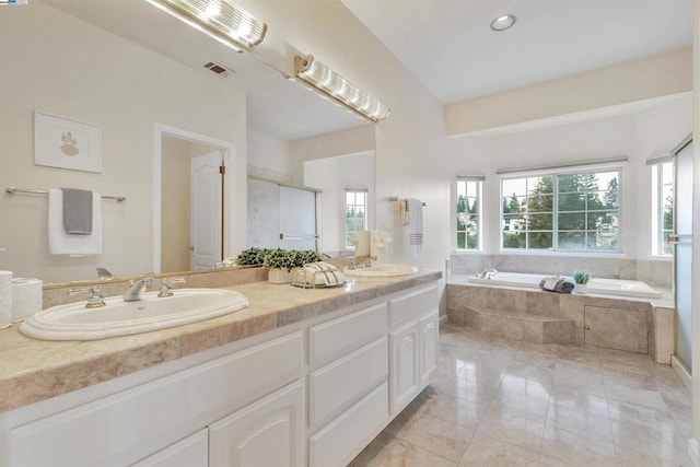 bathroom with vanity and shower with separate bathtub