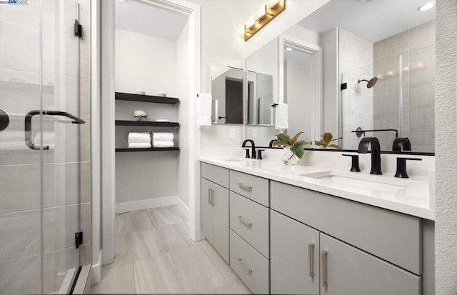 bathroom featuring a shower with door and vanity