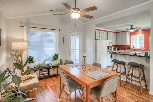 dining space featuring crown molding and light hardwood / wood-style floors