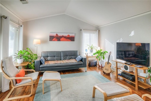 living room featuring vaulted ceiling, ornamental molding, a healthy amount of sunlight, and hardwood / wood-style flooring