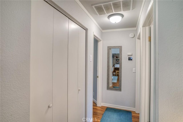 corridor featuring ornamental molding and hardwood / wood-style flooring