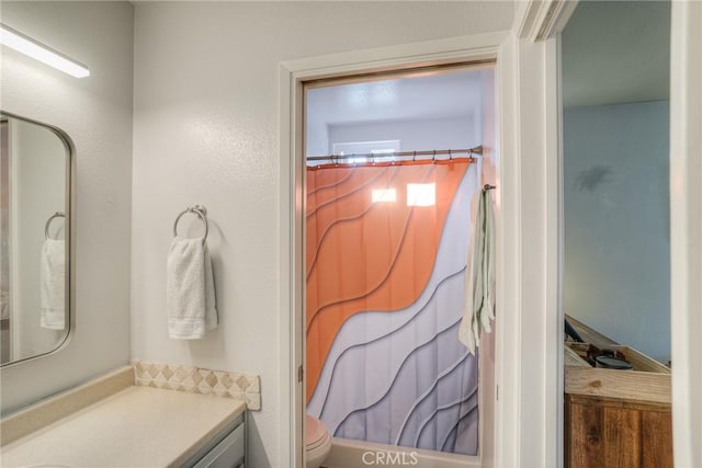 bathroom featuring toilet, vanity, and a shower with shower curtain