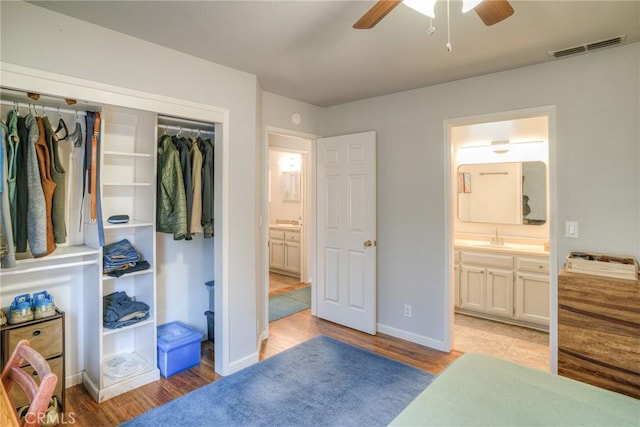 bedroom with ceiling fan, light hardwood / wood-style floors, a closet, and ensuite bath