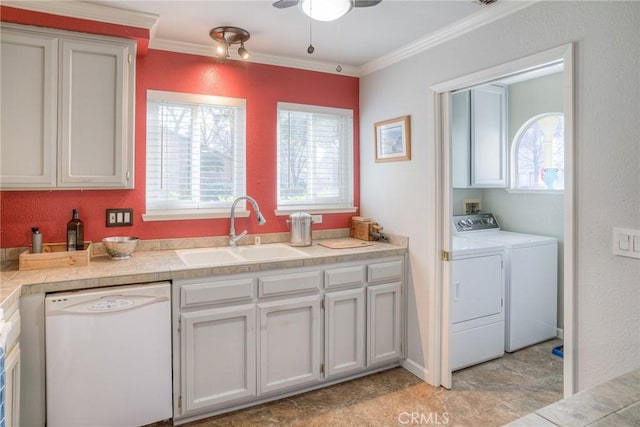 laundry area with washer and dryer, sink, cabinets, and ornamental molding