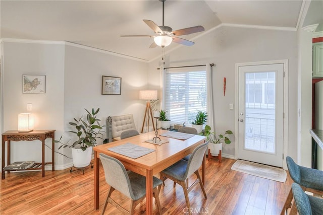 dining space featuring ceiling fan, light hardwood / wood-style flooring, lofted ceiling, and ornamental molding