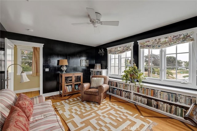 interior space featuring ceiling fan, wood-type flooring, and a wealth of natural light