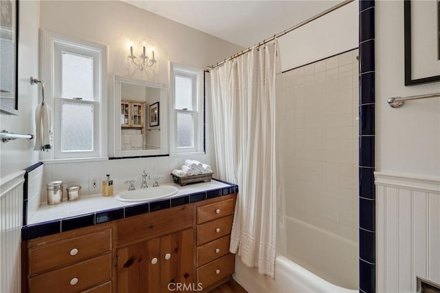 bathroom featuring tasteful backsplash, vanity, and shower / bath combo with shower curtain