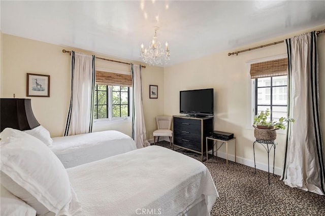 bedroom with carpet floors, a chandelier, and multiple windows