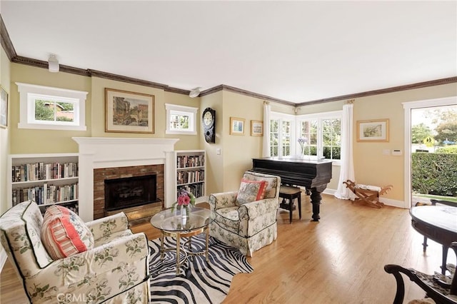 sitting room featuring a fireplace, ornamental molding, and light hardwood / wood-style flooring