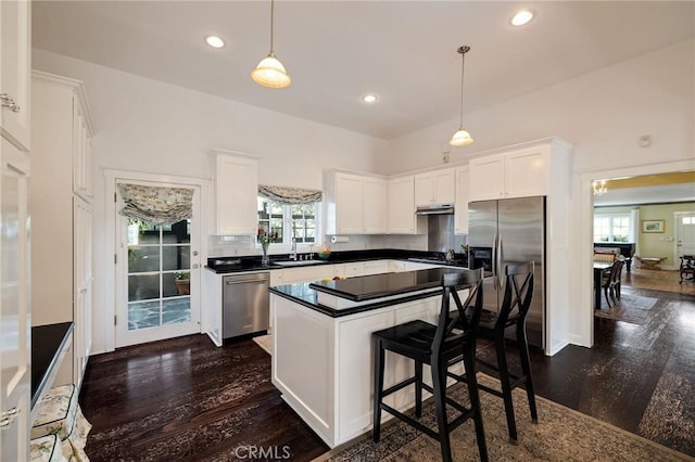 kitchen featuring sink, white cabinetry, hanging light fixtures, a healthy amount of sunlight, and appliances with stainless steel finishes