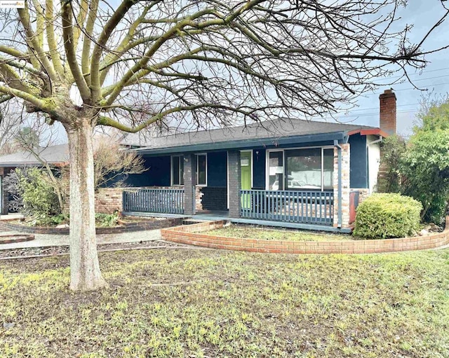 ranch-style house featuring a porch and a front yard