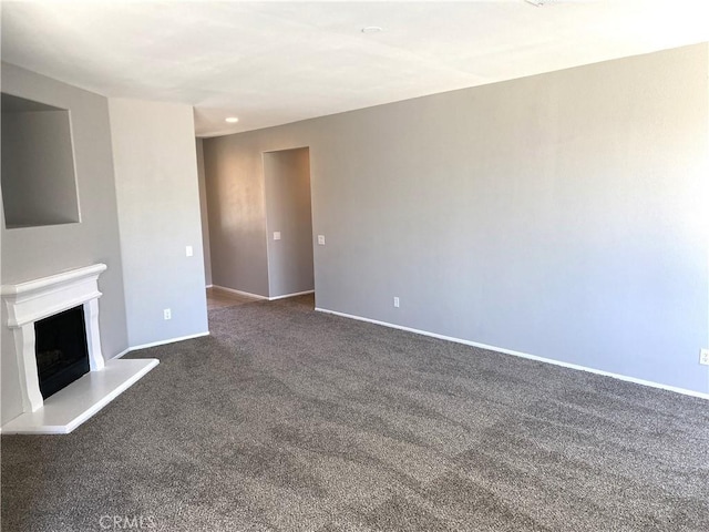 unfurnished living room with dark colored carpet