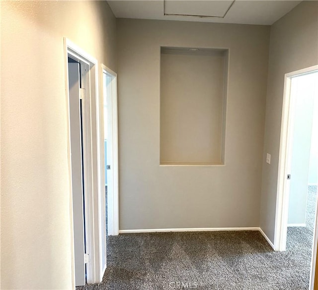 hall featuring dark colored carpet