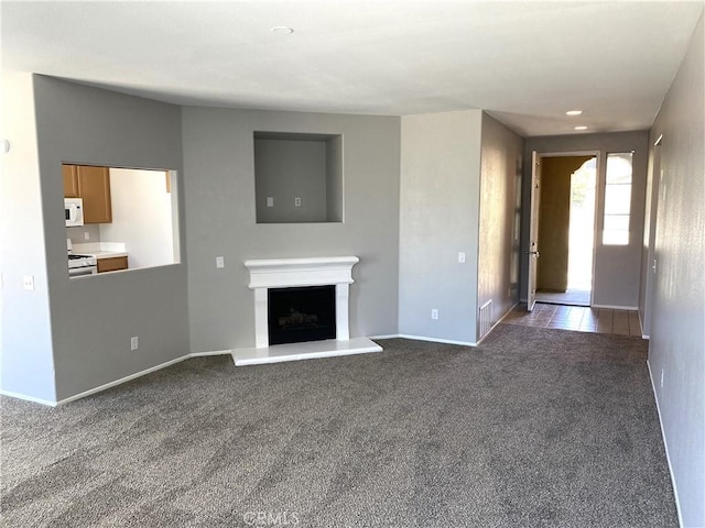 unfurnished living room featuring dark carpet