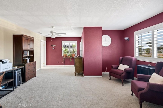 living area with light carpet, ceiling fan, and a textured ceiling