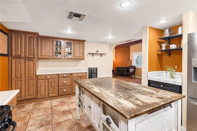 kitchen featuring stainless steel refrigerator with ice dispenser and light tile patterned flooring