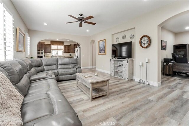 living room featuring light wood-type flooring and ceiling fan