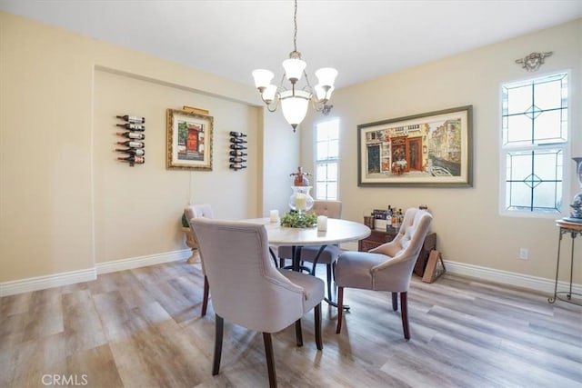 dining area with an inviting chandelier and light hardwood / wood-style floors