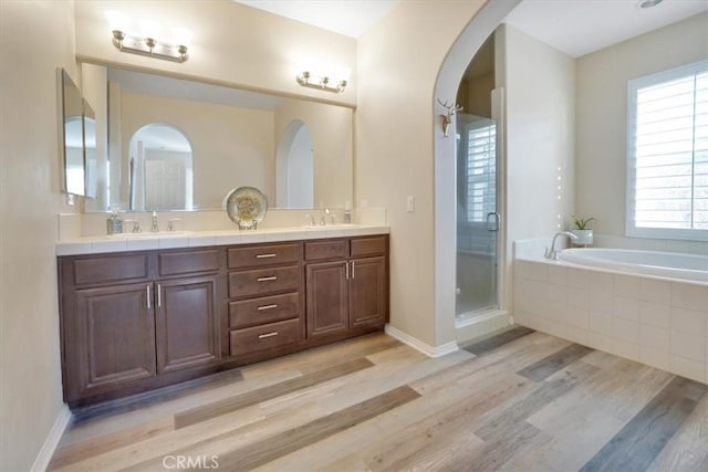 bathroom with separate shower and tub, hardwood / wood-style flooring, and vanity