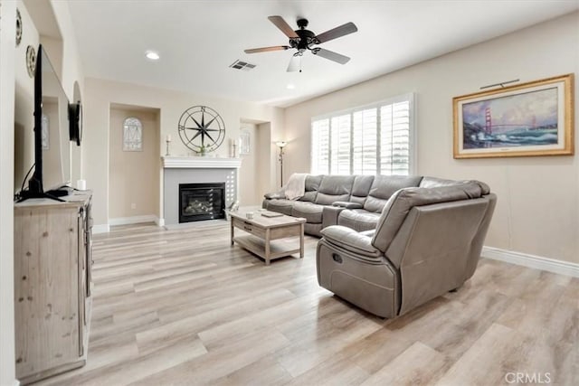 living room with ceiling fan and light hardwood / wood-style flooring