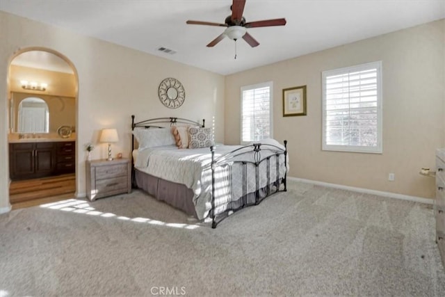 bedroom featuring ensuite bathroom, sink, ceiling fan, and light carpet