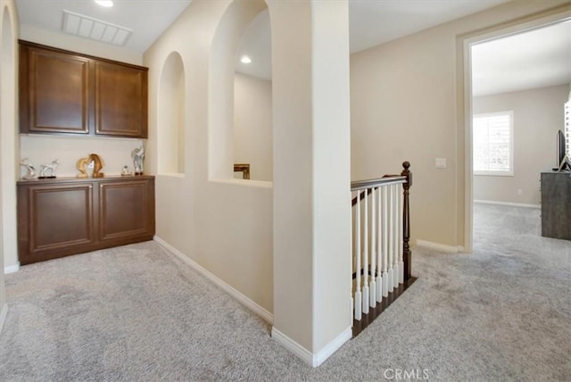 hall with light colored carpet