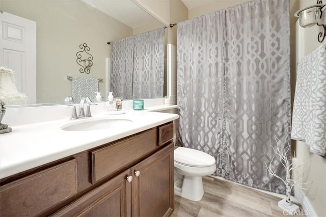 bathroom with toilet, wood-type flooring, and vanity