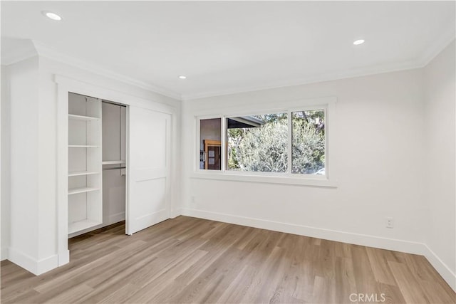 unfurnished bedroom featuring a closet, crown molding, and light hardwood / wood-style flooring