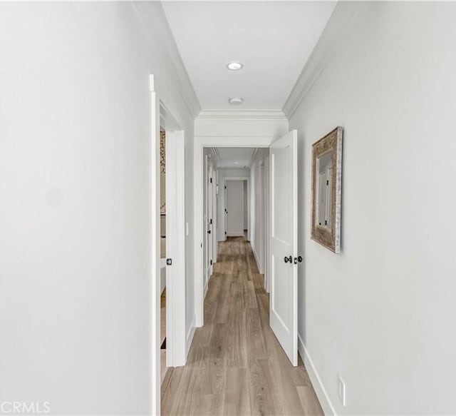 corridor featuring crown molding and light hardwood / wood-style floors