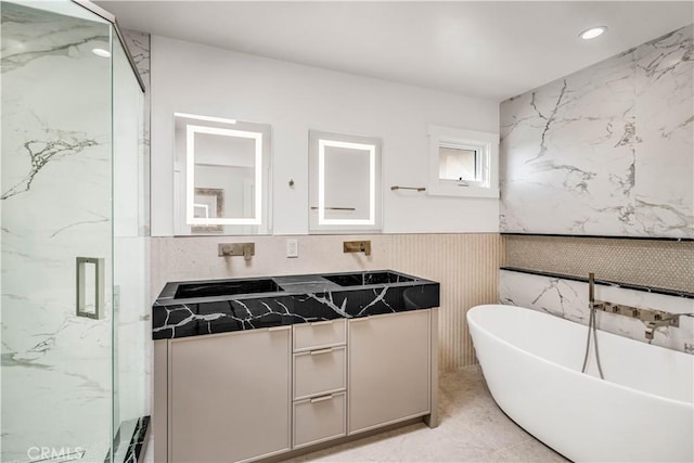 bathroom featuring vanity and independent shower and bath