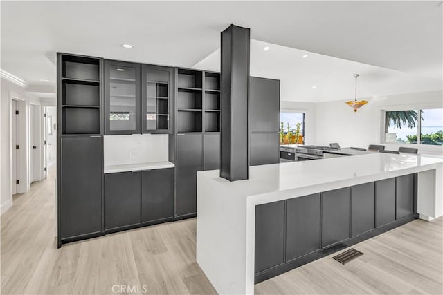 kitchen featuring light hardwood / wood-style floors, a spacious island, and pendant lighting