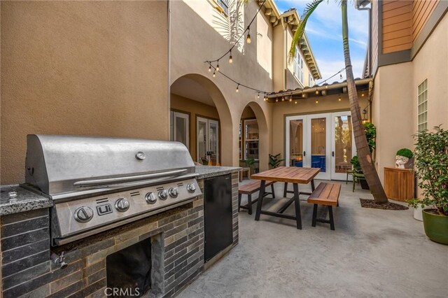 view of patio / terrace with grilling area, french doors, and an outdoor kitchen