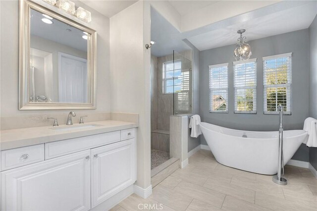 bathroom featuring vanity, a chandelier, and plus walk in shower