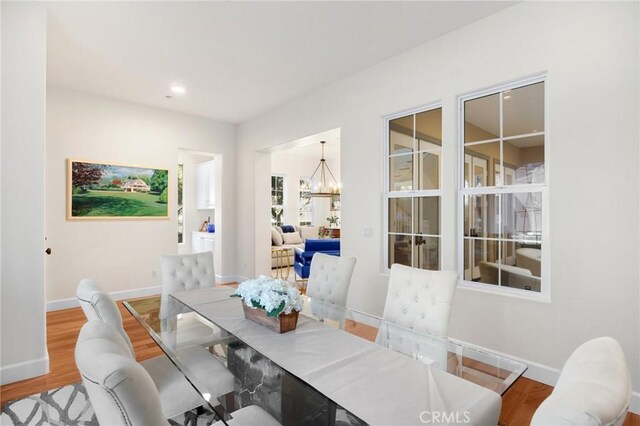 dining room with hardwood / wood-style flooring and a notable chandelier