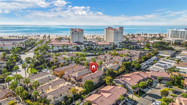 birds eye view of property with a water view and a beach view