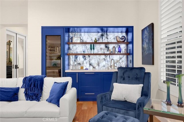 interior space with sink, dark wood-type flooring, french doors, and blue cabinetry