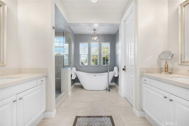 bathroom with a chandelier, vanity, separate shower and tub, and tile patterned flooring