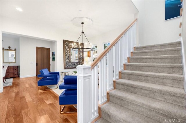 stairs featuring a chandelier and hardwood / wood-style floors