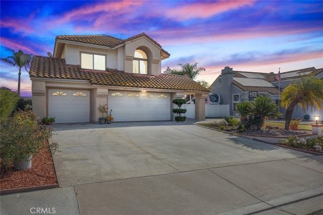 mediterranean / spanish-style home with a garage