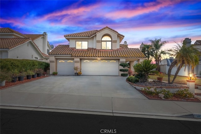 mediterranean / spanish-style home with a garage