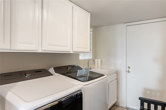 clothes washing area with light tile patterned flooring, cabinets, sink, and washing machine and dryer