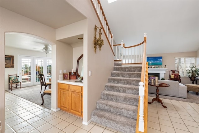 stairs featuring tile patterned floors and ceiling fan