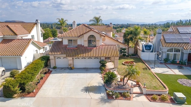 mediterranean / spanish-style home with a garage, a mountain view, and a front yard