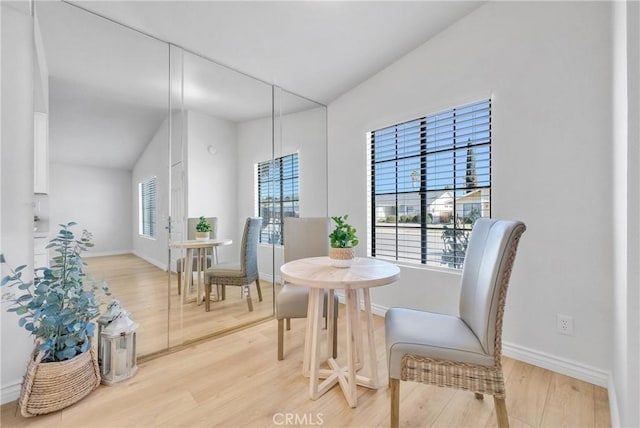 dining room featuring lofted ceiling and wood-type flooring