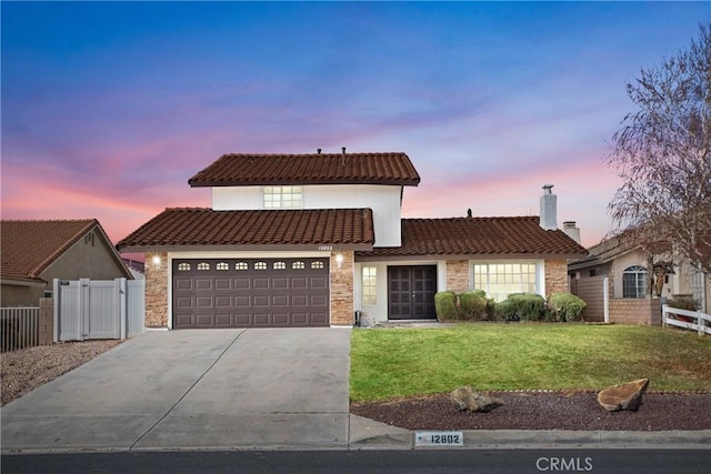 view of front of house with a garage and a yard