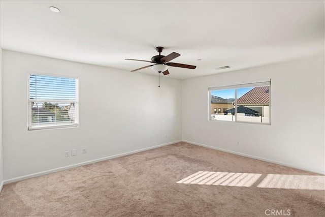 carpeted spare room with ceiling fan