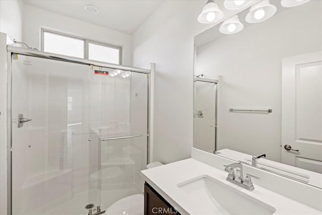 bathroom featuring toilet, an enclosed shower, and vanity